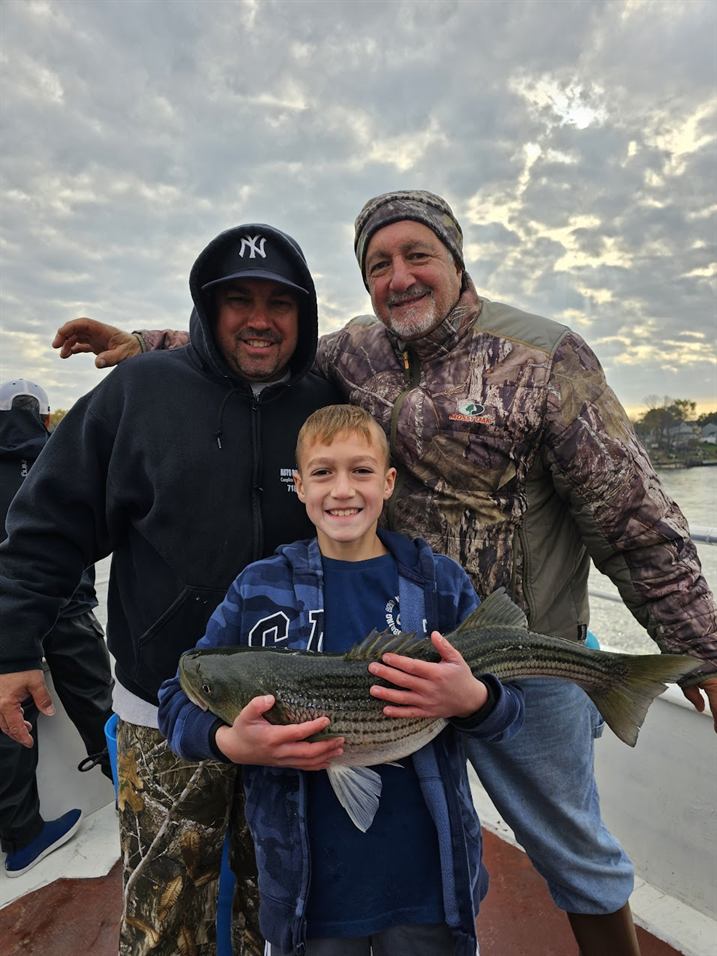 A family with a striped bass caught aboard
