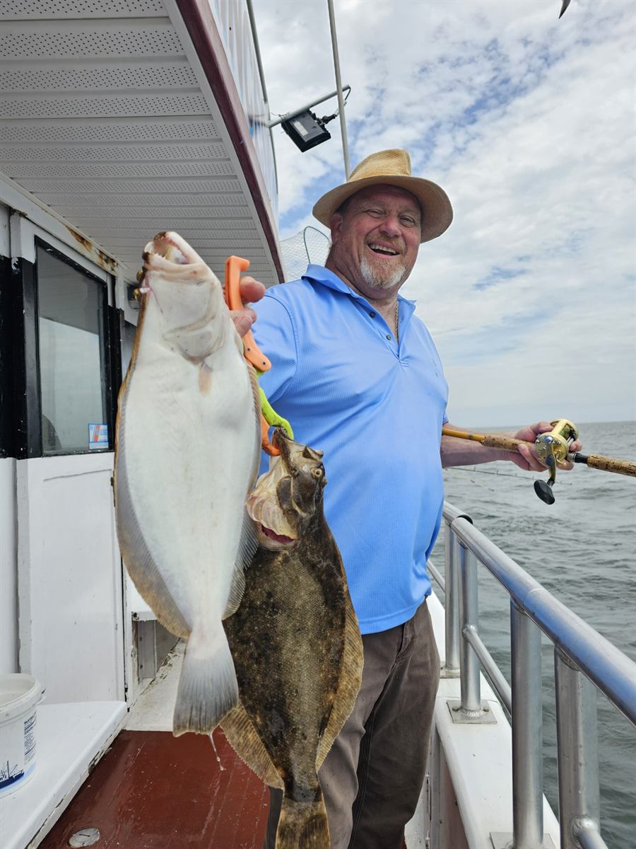 Angler holding two fluke